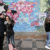Lennonova zeď po třech měsících od malování - turisté, graffiti