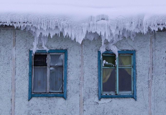 The roof of a house is covered with snow in the village of Tomtor in the Oymyakon valley in the Republic of Sakha, northeast Russia, January 24, 2013. The coldest temperatures in the northern hemisphere have been recorded in the Oymyakon valley, where according to the United Kingdom Met Office a temperature of -67.8 degrees Celsius (-90 degrees Fahrenheit) was registered in 1933 - the coldest on record in the northern hemisphere since the beginning of the 20th century. Yet despite the harsh climate, people live in the valley, and the area is equipped with schools, a post office, a bank, and even an airport runway (albeit open only in the summer). Picture taken January 24, 2013. REUTERS/Maxim Shemetov (RUSSIA - Tags: SOCIETY ENVIRONMENT) ATTENTION EDITORS: PICTURE 2 OF 27 FOR PACKAGE 'THE POLE OF COLD' SEARCH 'MAXIM COLD' FOR ALL IMAGES Published: Úno. 18, 2013, 11:25 dop.