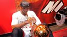 Miami Heat's Dwyane Wade sits with the Larry O'Brien Trophy after his team defeated the San Antonio Spurs in Game 7 to win their NBA Finals basketball playoff in Miami, F