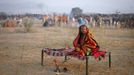 A camel herder sits on a bed in a field during the early morning at Pushkar Fair in the desert Indian state of Rajasthan November 23, 2012. Many international and domestic tourists throng to Pushkar to witness one of the most colourful and popular fairs in India. Thousands of animals, mainly camels, are brought to the fair to be sold and traded. REUTERS/Danish Siddiqui (INDIA - Tags: SOCIETY ANIMALS ENVIRONMENT) Published: Lis. 23, 2012, 8:08 dop.