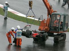 Pořadatelé odklízejí z trati ve Fudži rozbitý monopost McLaren Fernanda Alonsa.