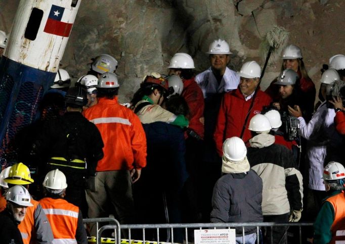 Přímo u otvoru, jimiž jsou horníci taháni, čekala na Ávalose rodina