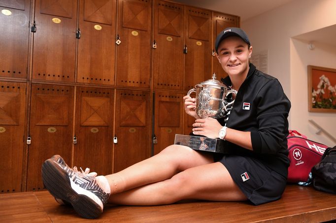 In this handout photograph released by the French Tennis Federation Australia's Ashleigh Barty poses with her Suzanne Lenglen trophy in the changing room, after winning t