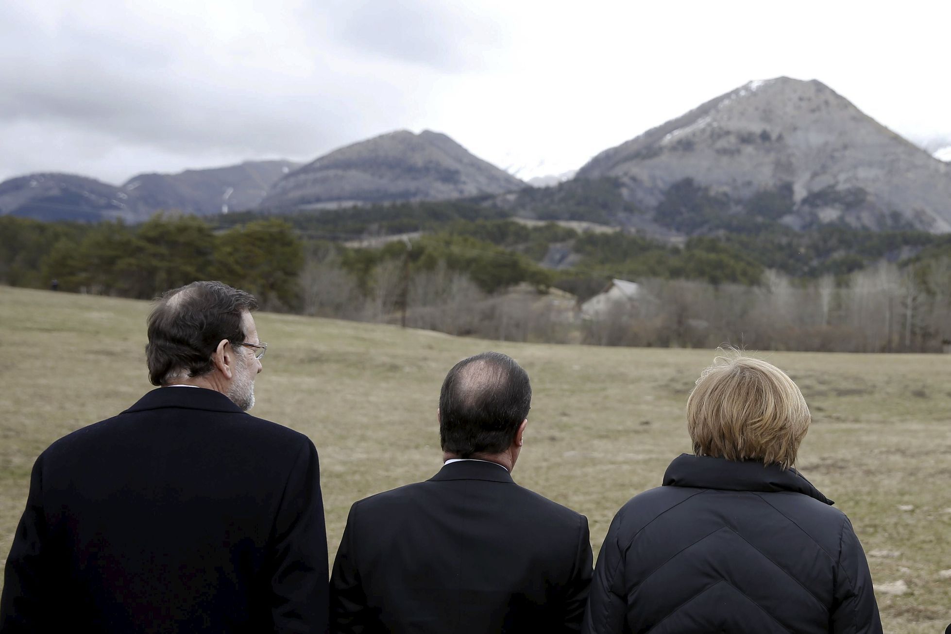 Rajoy, Hollande a Merkelová se dívají směrem k místů, kde se letoun roztříštil.