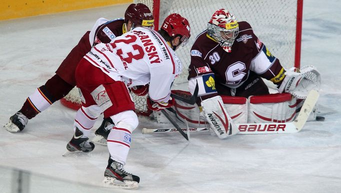 Forvard Jiří Polanský (v bílém) se do statistik zápasu zapsal jen touto nevydařenou střelou na Michala Neuvirtha a jedním dvouminutovým trestem.