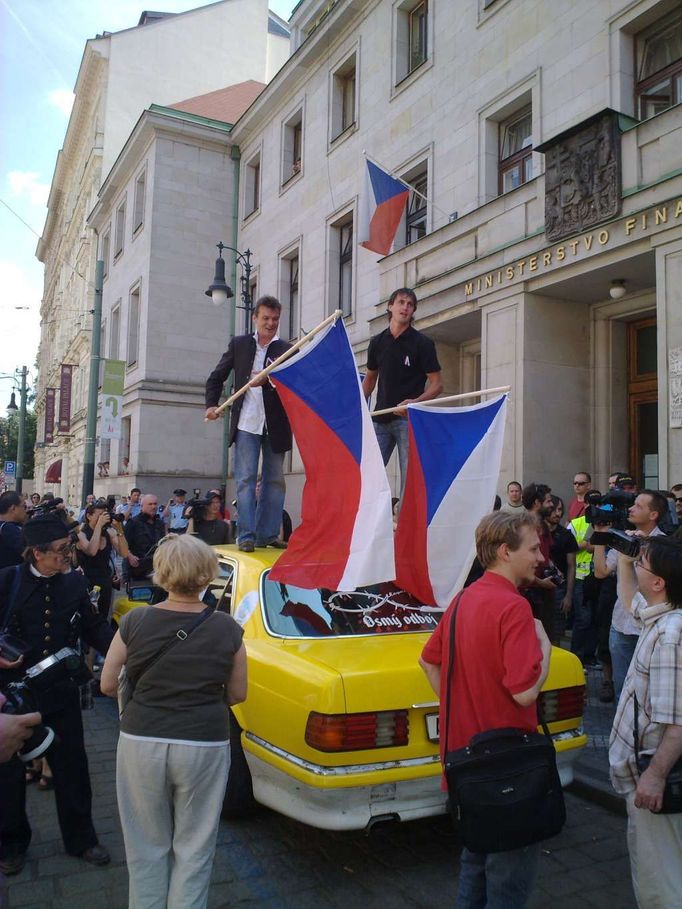 Před ministerstvem financí čeká a vykřikuje známý pražský taxikář a provokatér.