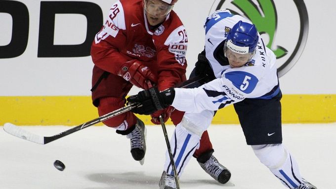 Fin Lasse Kukkonen bojuje o puk s Dánem Mortenem Madsenem v zápase základní skupiny D na MS v hokeji na Slovensku (Bratislava)