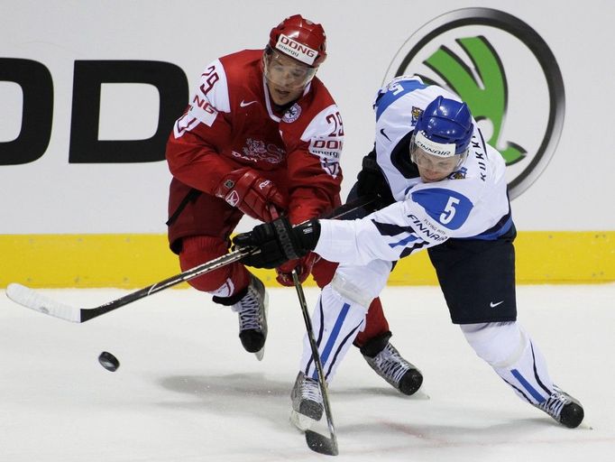 Fin Lasse Kukkonen bojuje o puk s Dánem Mortenem Madsenem v zápase základní skupiny D na MS v hokeji na Slovensku (Bratislava)