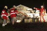 Záchranáři zkoumají trosky budovy, do které letadlo při svém pádu narazilo.