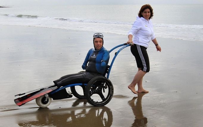 File photo dated 16/09/10 of French limbless swimmer Philippe Croizon is helped into the sea by team member Valerie Carbonnel during a training session in Folkestone, Kent. Philippe Croizon today became the first limbless person to swim the Channel.