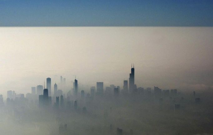 Blue sky is seen over a blanket of fog enveloping the skyline of Chicago, as photographed from an airplane window November 21, 2012. Unseasonably warm temperatures created a heavy fog along Chicago's Lake Michigan. The blue line is formed by the clouds and fog meeting the sky. REUTERS/Kevin Lamarque (UNITED STATES - Tags: SOCIETY CITYSPACE ENVIRONMENT) Published: Lis. 22, 2012, 1:12 dop.