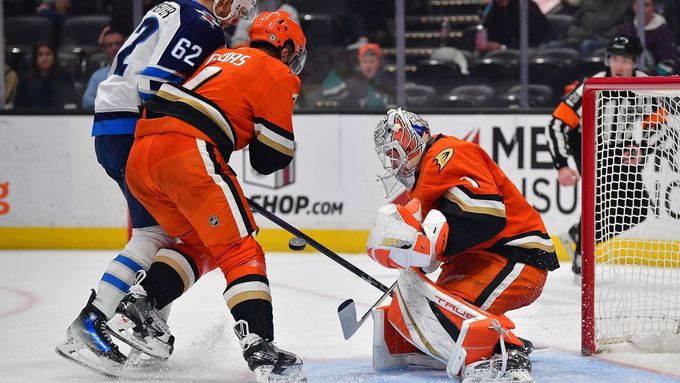 Radko Gudas a brankář Lukáš Dostál při společné obranné práci zastavují výpad Nina Niederreitera z Winnipegu