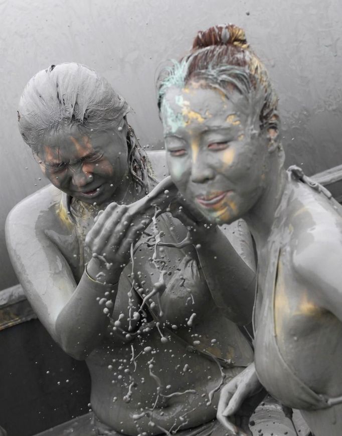 People play in the mud during the Boryeong Mud Festival at Daecheon beach in Boryeong, about 190 km (118 miles) southwest of Seoul, July 15, 2012. About 2 to 3 million domestic and international tourists visit the beach during the annual mud festival, according to the festival organisers. REUTERS/Lee Jae-Won (SOUTH KOREA - Tags: SOCIETY TRAVEL) Published: Čec. 15, 2012, 6:56 dop.