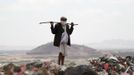 A man stands at a garbage disposal site near Sanaa