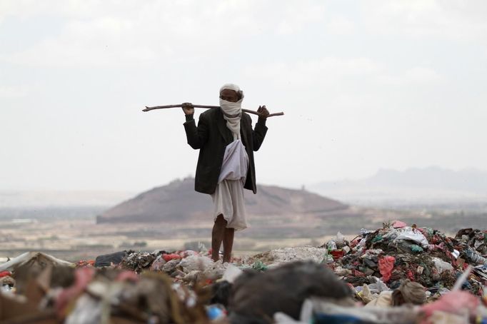 A man stands at a garbage disposal site near Sanaa