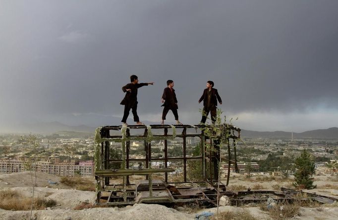 RNPS IMAGES OF THE YEAR 2012 - Afghan boys play on a destroyed car at a hilltop in Kabul October 18, 2012. REUTERS/Mohammad Ismail (AFGHANISTAN - Tags: SOCIETY TPX IMAGES OF THE DAY) Published: Pro. 4, 2012, 1:11 dop.