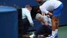 Sep 6, 2020; Flushing Meadows, New York, USA; Novak Djokovic of Serbia and a tournament official tend to a linesperson who was struck with a ball by Djokovic against Pabl