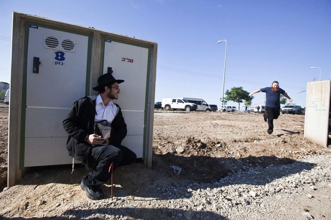 An Israeli civilian runs to take cover as a siren sounds warning of incoming rockets at the scene where a rocket, fired from Gaza, landed in the southern town of Kiryat Malachi November 15, 2012. A Hamas rocket killed three Israelis north of the Gaza Strip on Thursday, drawing the first blood from Israel as the Palestinian death toll rose to 13 and a military showdown lurched closer to all-out war with an invasion of the enclave. REUTERS/Nir Elias (ISRAEL - Tags: POLITICS CIVIL UNREST) Published: Lis. 15, 2012, 1:58 odp.