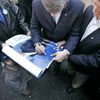 Konzervativec Stephen Harper podepisuje volební plakáty
