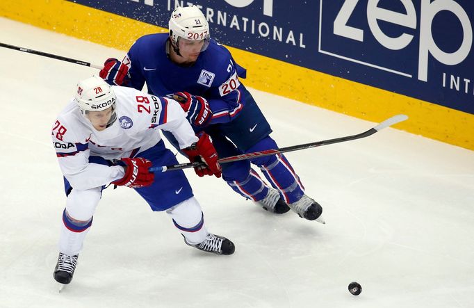 Norway's Niklas Roest (L) battles for the puck with France's Antoine Roussel (R) during the second period of their men's ice hockey World Championship Group A game at Chi