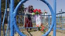 Belarussian woman stands at her relative's grave on the eve of Radunitsa in the abandoned village of Tulgovichi