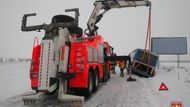 Vyprošťovací vozidlo Bizon vyzvedávalo pomocí hydraulického ramene na silnici zadní část autobusu.