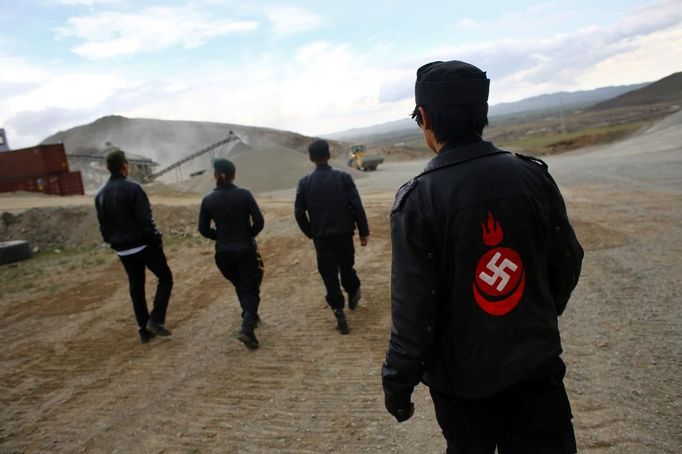 Members of the Mongolian neo-Nazi group Tsagaan Khass walk through a quarry, where they questioned a worker, southwest of Ulan Bator June 23, 2013. The group has rebranded itself as an environmentalist organisation fighting pollution by foreign-owned mines, seeking legitimacy as it sends Swastika-wearing members to check mining permits. Over the past years, ultra-nationalist groups have expanded in the country and among those garnering attention is Tsagaan Khass, which has recently shifted its focus from activities such as attacks on women it accuses of consorting with foreign men to environmental issues, with the stated goal of protecting Mongolia from foreign mining interests. This ultra-nationalist group was founded in the 1990s and currently has 100-plus members. Picture taken June 23, 2013. REUTERS/Carlos Barria (MONGOLIA - Tags: POLITICS ENVIRONMENT BUSINESS SOCIETY EMPLOYMENT) ATTENTION EDITORS: PICTURE 21 OF 25 FOR PACKAGE 'MONGOLIA'S ENVIRONMENTAL NEO-NAZIS'. TO FIND ALL IMAGES SEARCH 'TSAGAAN KHASS' Published: Čec. 2, 2013, 9:58 dop.