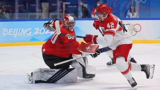 Mikkel Aagaard a švýcarský brankář Reto Berra v zápase Švýcarsko - Dánsko na ZOH 2022 v Pekingu