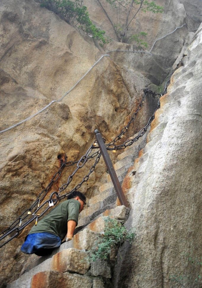 HUAYIN, CHINA - AUGUST 13: (CHINA OUT) Legless man Chen Zhou climbs the Huashan Mountain on August 13, 2012 in Huayin, Shaanxi Province of China. Legless 29-year-old man Chen Zhou from Cangshan of Shandong Province spent two days, 19 hours in total, climbing by arms to the top of Huashan Mountain. Chen lost his legs after falling off a train at the age of 13, but he has since strived to be stronger and joined in many public performances to encourage other people. Chen Zhou will climb the Taishan Mountain in Shandong province in the following months. ( automatický překlad do češtiny )