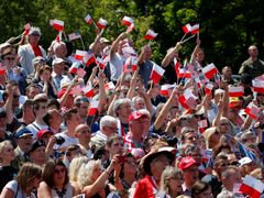 Trumpa ve Varšavě vítají davy s vlaječkami.