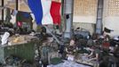 French soldiers talk under a French flag in a hangar at the Malian army air base in Bamako January 14, 2013. France, which has poured hundreds of troops into the capital Bamako in recent days, carried out more air raids on Monday in the vast desert area seized last year by an Islamist alliance grouping al Qaeda's north African wing AQIM alongside Mali's home-grown MUJWA and Ansar Dine militant groups. REUTERS/Joe Penney (MALI - Tags: POLITICS MILITARY CONFLICT) Published: Led. 14, 2013, 6:04 odp.