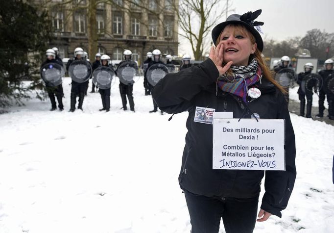 An Arcelor Mittal worker from Liege displays a placard around her neck reading "Billions for Dexia, How much for the Liege steel workers?", during a demonstration outside Prime Minister Elio Di Rupo's office in Brussels January 25, 2013. ArcelorMittal, the world's largest steel producer, plans to shut a coke plant and six finishing lines at its site in Liege, affecting 1,300 employees, the group said on Thursday. REUTERS/Eric Vidal (BELGIUM - Tags: BUSINESS CIVIL UNREST EMPLOYMENT) Published: Led. 25, 2013, 2:44 odp.