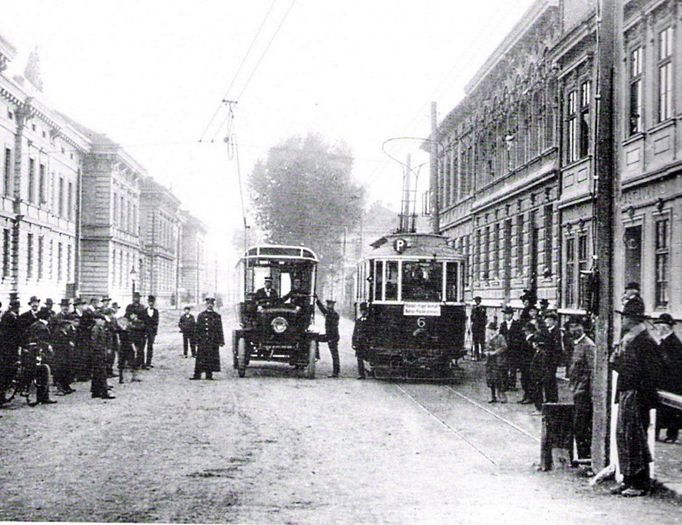 Trolejbus Daimler-Stoll (vlevo) v budějovických ulicích. Vpravo tramvaj Rindhoffer. Po roce 1909.