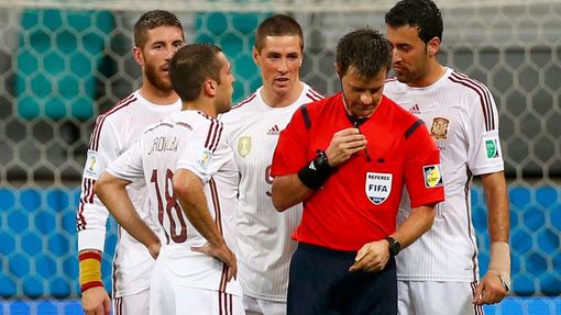 Spain's players crowd around referee Nicola Rizzoli of Italy in protest after the conceeded a goal to the Netherlands during their 2014 World Cup Group B soccer match aga