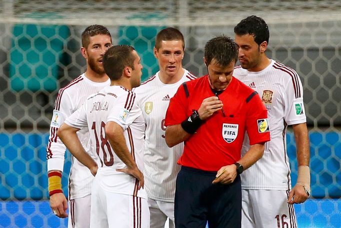 Spain's players crowd around referee Nicola Rizzoli of Italy in protest after the conceeded a goal to the Netherlands during their 2014 World Cup Group B soccer match aga