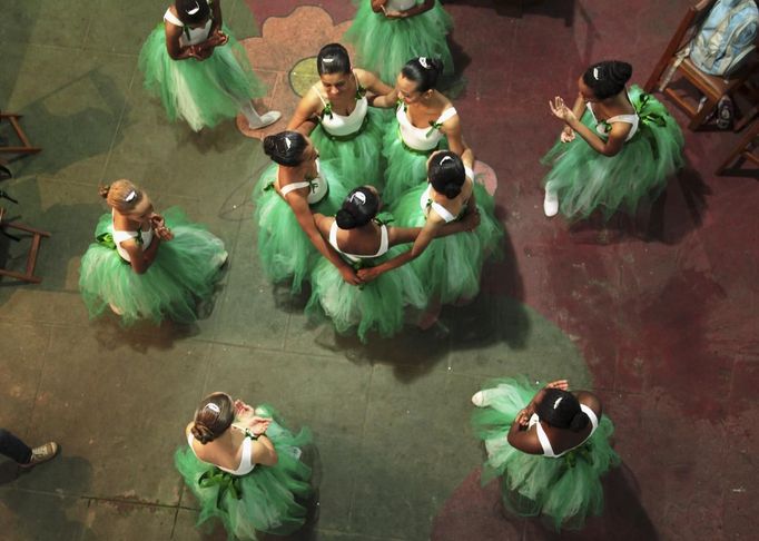 Girls perform during their ballet class at the 'Ballet Santa Teresa' academy in Rio de Janeiro August 13, 2012. 'Ballet Santa Teresa', a non-governmental organization (NGO) gives children who live in areas with social risk, some suffering domestic violence, free ballet classes and other activities as a part of socio-cultural integration project. Picture taken Auhust 13, 2012. REUTERS/Pilar Olivares (BRAZIL - Tags: SOCIETY) Published: Srp. 16, 2012, 7:39 odp.