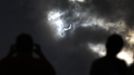 Tourists watch as the moon blocks the sun as it approaches a full solar eclipse in the northern Australian city of Cairns November 14, 2012. REUTERS/Tim Wimborne (AUSTRALIA - Tags: SOCIETY ENVIRONMENT) Published: Lis. 13, 2012, 9:28 odp.