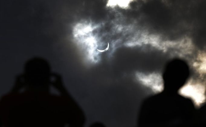 Tourists watch as the moon blocks the sun as it approaches a full solar eclipse in the northern Australian city of Cairns November 14, 2012. REUTERS/Tim Wimborne (AUSTRALIA - Tags: SOCIETY ENVIRONMENT) Published: Lis. 13, 2012, 9:28 odp.