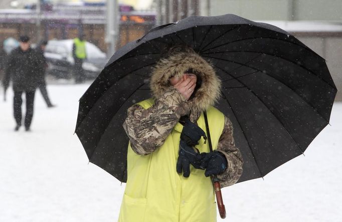 A man stands under an umbrella during a snowfall, with the air temperature at about minus 9 degrees Celsius (15.8 degrees Fahrenheit), in central Moscow, March 13, 2013. REUTERS/Sergei Karpukhin (RUSSIA - Tags: ENVIRONMENT) Published: Bře. 13, 2013, 8:43 dop.