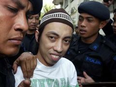 Indonéská policie přivádí do soudní síně jednoho z obžalovaných.