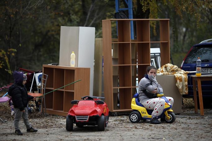 Aroa Gabarri Valdes, 12, sits next to her family belongings as her cousin Andy plays nearby after a bulldozer demolished her home at the Spanish gypsy settlement of Puerta de Hierro, in the outskirts of Madrid November 20, 2012. Fifty-four families have been living in Puerta de Hierro, on the banks of the Manzanares river for over 50 years. Since the summer of 2010, the community has been subject to evictions on the grounds that the dwellings are illegal. Families, whose homes have been demolished, move in with relatives whose houses still remain while the debris keeps piling up around them as more demolitions take place. REUTERS/Susana Vera (SPAIN - Tags: CIVIL UNREST BUSINESS CONSTRUCTION) Published: Lis. 20, 2012, 5:07 odp.