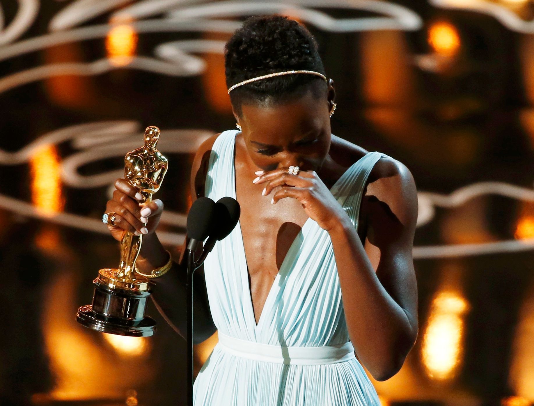 Nyong'o, best supporting actress winner for her role in &quot;12 Years a Slave&quot;, racts on stage at the 86th Academy Awards in Hollywood
