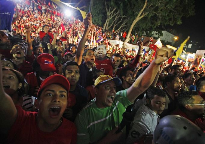 Supporters of Venezuelan President Hugo Chavez cheer as he appears on a balcony of Miraflores Palace in Caracas October 7, 2012. Venezuela's socialist President Hugo Chavez won re-election in Sunday's vote with 54 percent of the ballot to beat opposition challenger Henrique Capriles. REUTERS/Tomas Bravo (VENEZUELA - Tags: POLITICS ELECTIONS) Published: Říj. 8, 2012, 5:48 dop.