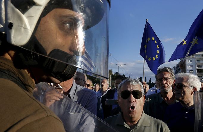 Policista mezi demonstranty v Aténách. Do ulic vyšli v pondělí zastánci i odpůrci eurozóny.