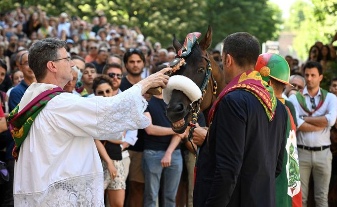 Kůň Zio Frac a jeho žokej Tittia, závodící za kontrádu Drago, dostávají před závodem požehnání