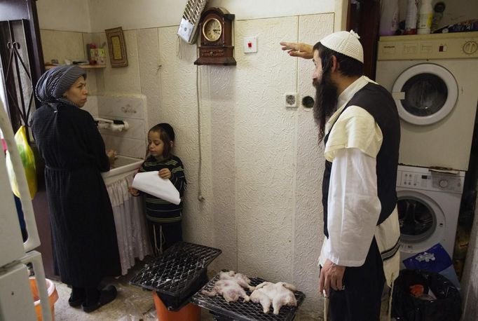 Rachel Kreus (L) speaks with her husband Yoel during the family's preparations for the Jewish Sabbath in Jerusalem's Mea Shearim neighbourhood June 29, 2012. The Kreus family are a member of Neturei Karta, a fringe ultra-Orthodox movement within the anti-Zionist bloc. The ultra-Orthodox Jews have gone from being a tiny minority in Israel's mostly secular society to its fastest-growing sector, now about 10 percent of the 7.8 million population. They are exempt from military duty in Israel but draft deferments and state subsidies for the ultra-Orthodox have become a divisive political issue in Israel, where the government must decide a new law by August to ensure more of them do military service. Picture taken June 29, 2012. REUTERS/Ronen Zvulun (JERUSALEM - Tags: RELIGION MILITARY POLITICS CIVIL UNREST) ATTENTION EDITORS - PICTURE 13 OF 21 FOR PACKAGE "ISRAEL'S ULTRA-ORTHODOX". SEARCH "ULTRA-ORTHODOX" FOR ALL PICTURES Published: Čec. 6, 2012, 10:03 dop.