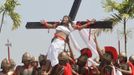 Ruben Enaje, 52, who is portraying Jesus Christ for the 27th time, is raised on a wooden cross by a group of men playing Roman soldiers after he was nailed to it during a Good Friday crucifixion re-enactment in San Pedro Cutud town, Pampanga province, north of Manila March 29, 2013. The Roman Catholic church frowns upon the gory spectacle held in the Philippine village of Cutud every Good Friday but does nothing to deter the faithful from emulating the suffering of Christ and taking a painful route to penitence. Holy Week is celebrated in many Christian traditions during the week before Easter. REUTERS/Romeo Ranoco (PHILIPPINES - Tags: RELIGION SOCIETY) Published: Bře. 29, 2013, 7:24 dop.