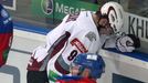 Hokejista Krisjanis Redlihs (vzadu) brání puk před Jiřím Novotným v utkání KHL 2012/13 mezi Lvem Praha s Dinamem Riga .