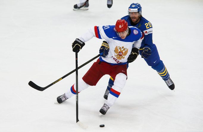 Russia's Yevgeni Malkin battles for the puck with Sweden's Joel Lundqvist (R) during the first period of their men's ice hockey World Championship semi-final game at Mins