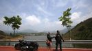 A couple stand next to their Harley Davidson motorcycle as they attend the annual Harley Davidson National Rally in Qian Dao Lake, in Zhejiang Province May 11, 2013. Around 1,000 Harley Davidson enthusiasts from all over China met to celebrate the 5th Harley Davidson National Rally in China, as part of the company's 110-year anniversary. Major Chinese cities ban motorcycles from circulating on highways and major avenues. Meanwhile, Harley Davidson motorbikes are considered by Chinese tax authorities to be luxury items, so they are taxed at extremely high rates-- sometimes the taxes alone is equivalent to the bike's U.S. price tag. Traffic and transportation authorities have also weighed in, putting Harleys in the same category as electric bikes, horses and bicycles, meaning that they cannot be on highways and major avenues. Picture taken May 11, 2013. REUTERS/Carlos Barria (CHINA - Tags: TRANSPORT SOCIETY) Published: Kvě. 13, 2013, 11:05 odp.